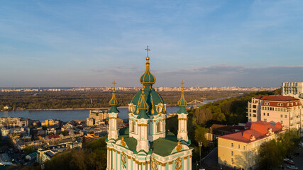 Aerial view Kyiv St. Andrews Church at beautiful sunset. Drone flies over old Kiev - podil. Andrews Descent