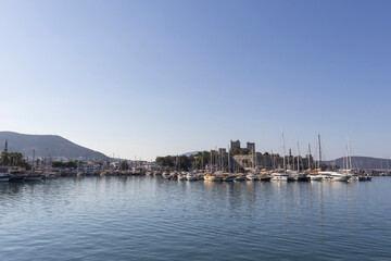 Obraz premium A quiet morning in Bodrum, Muğla, boats in the harbor and Bodrum Castle.
