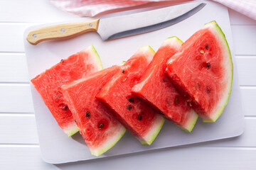 Slices of red watermelon on cutting board.