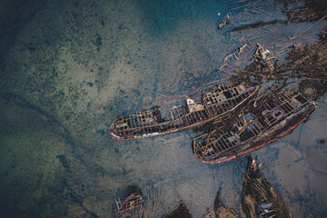 Destroyed wooden pirate ships washed up on the seashore, Aerial top view