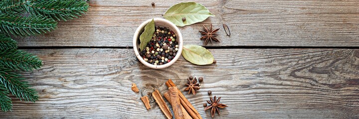 Traditional Christmas spices for cooking and drink (mulled wine) on a wooden background with fir...