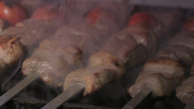 Close-up of lumpy kebab with tomato and ground kebab is grilled on the grill
