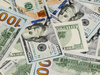 Large pile of hundred dollar bills in background view.