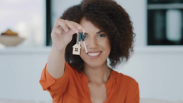 Portrait African exited woman looks at camera showing bunch keys celebrates success buying new home. Euphoric lady gets real estate opportunity rejoices apartment selling property dwelling relocation