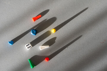 Colored game chips and playing cubes laid out on a gray background. entertainment, games at home for the whole family, the concept of board games. Board game. Table games