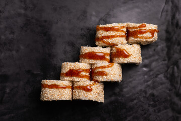 California sushi roll covered with sauce on black surface flat lay © Andrii