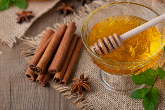 Honey, spice of cinnamon sticks and fresh mint isolated on an old wooden table