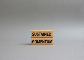 Sustained momentum symbol. Wooden blocks with words Sustained momentum. Beautiful grey background. Business and Sustained momentum concept. Copy space.
