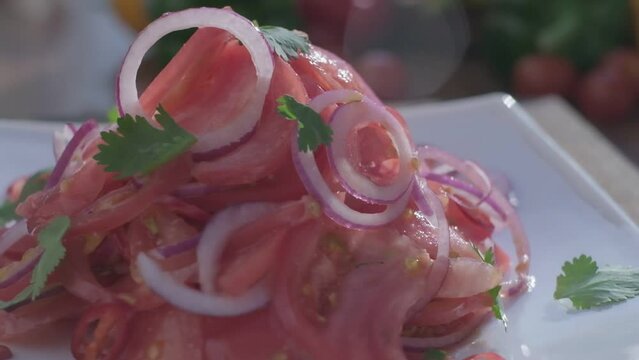 Close-up of fresh salad made of red cabbige, tomatoes, onions, basil, arugula and pieces of fried meat