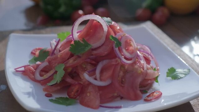 Close-up of fresh salad made of red cabbige, tomatoes, onions, basil, arugula and pieces of fried meat