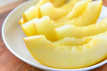 a plate full of sliced melon on a wooden board, the concept of fresh fruit and healthy food