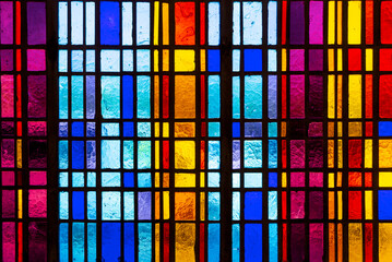 Colorful stained glass window in modern design with blue, red, violet and yellow pieces of glass - 524128574