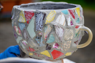 Homemade mosaic flower pot with porcelain pieces. Recycling, broken tableware, ceramics, crafts, mosaics.