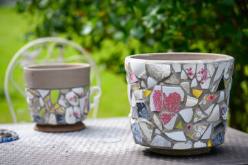 Homemade mosaic flower pot with porcelain pieces. Recycling, broken tableware, ceramics, crafts, mosaics.