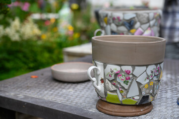Homemade mosaic flower pot with porcelain pieces. Recycling, broken tableware, ceramics, crafts, mosaics.
