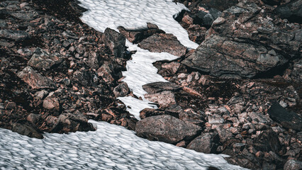 Closeup rocky mountain side with snow