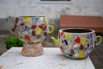 Homemade mosaic flower pot with porcelain pieces. Recycling, broken tableware, ceramics, crafts, mosaics.