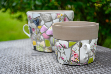 Homemade mosaic flower pot with porcelain pieces. Recycling, broken tableware, ceramics, crafts, mosaics.