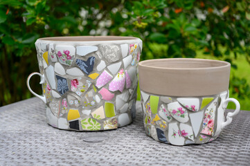 Homemade mosaic flower pot with porcelain pieces. Recycling, broken tableware, ceramics, crafts, mosaics.