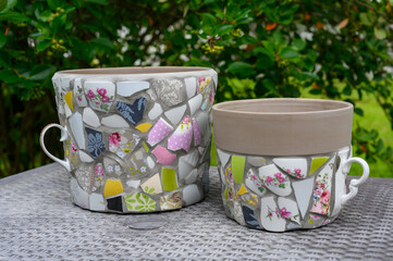 Homemade mosaic flower pot with porcelain pieces. Recycling, broken tableware, ceramics, crafts, mosaics.