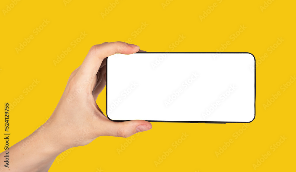 Poster Hand holding phone mockup in horizontal position on yellow background. Woman using smartphone for watching video. Android template with empty screen. High quality photo