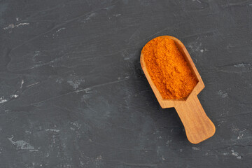 Red chili pepper spice wooden scoop on black concrete background. Macro. Top view. Diet and weight loss concept - Powered by Adobe