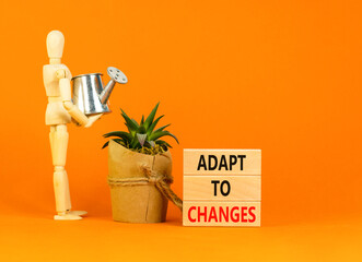 Adapt to changes symbol. Concept words Adapt to changes on wooden blocks. Businessman model....