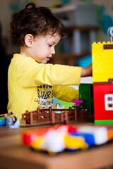 Baby boy playing with construction toy blocks at home. Kids playing. Children at day care. Child...
