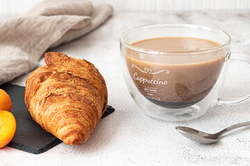 Fresh croissant with apricots and coffee. French breakfast concept