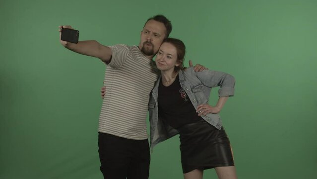 Caucasians in casual clothes take pictures against the background of a chromakey