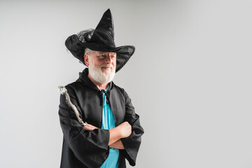 old wizard man  shows magic wand in a Halloween costume, on a white background