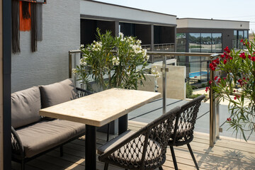 Cozy tables on the open summer terrace of the restaurant. Large potted plants, oleander