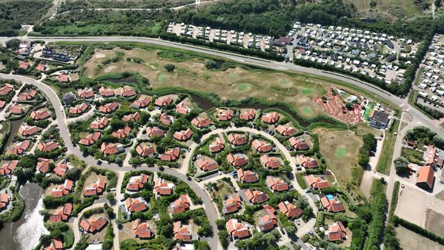 Vacation bungalow park accomodation leisure resort in Zeeland, The Netherlands. Summer cabin village on the sea side. Summer cottage overhead drone aerial to spend holidays.