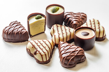 tasty background of assorted gourmet chocolate sweets on white surface
