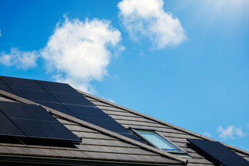 Fototapeta premium Solar panels on the house roof in sunny day. Renewable clean green energy generation.