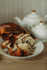 Delicious homemade chocolate pie, white teapot and sugar bowl on the table.