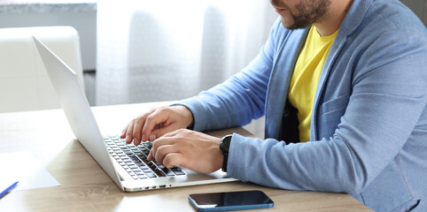 Man typing with hands on computer keyboard closeup, businessman or student using laptop at home, online learning, internet marketing, work from home, office workplace, freelance concept