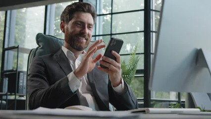 Busy Caucasian bearded man middle-aged 40s businessman uses phone mobile app texting chatting texting message working in office sitting desk with computer remote communicating browsing business chat - Powered by Adobe