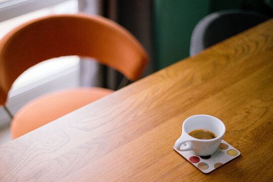 Espresso coffee at a kitchen table with orange chair