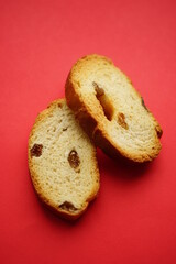 Two crackers with raisins on a red table, top view