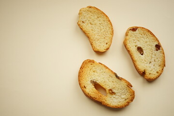 Three crackers with raisins on a beige table, top view