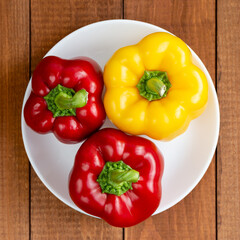 Ripe bell pepper on a white plate. A plate with vegetables on the table. Suitable for vegetarians. Diet food.