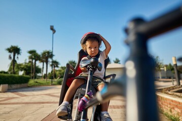 cute little boy with big bike outdoors in city street. High quality photo