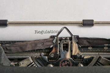 Vintage mechanical typewriter printing ‘Regulation’