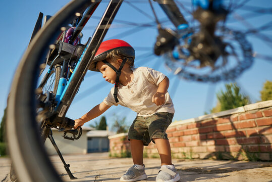 cute little boy with big bike outdoors in city street. High quality photo