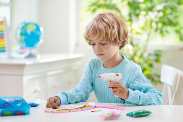 Crafts for kids. Child with hot glue gun.