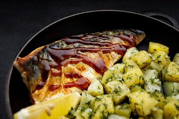 Baked mackerel fish fillet with potatoes in a pan