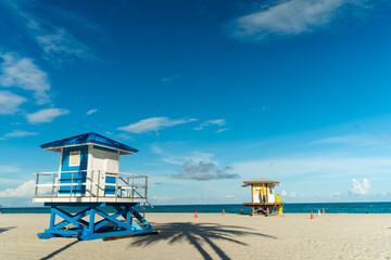 Lifeguard house on Hollywood beach in Florida, clean sand with ocean and blue sky in the background.