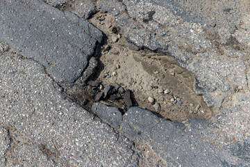 An old paved road with a lot of holes and damage