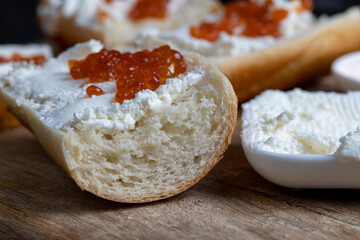 making sandwiches with baguette and cream cheese with caviar